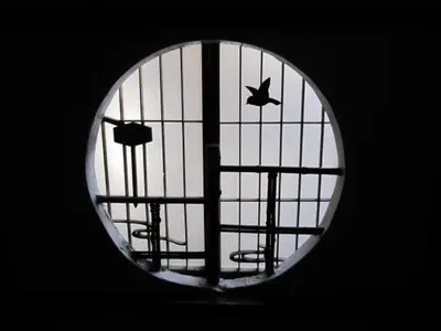 a round window with a view of a playground at Taito Ryokan in Tokyo