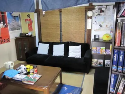 a living room with a black couch and a table at Taito Ryokan in Tokyo