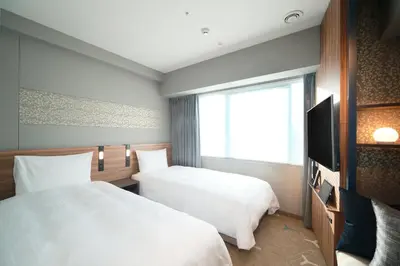 a hotel room with two beds and a television at Miyako City Tokyo Takanawa in Tokyo
