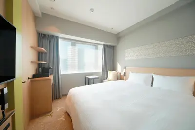 a bedroom with a large white bed and a window at Miyako City Tokyo Takanawa in Tokyo