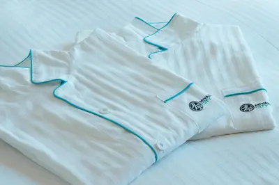 a white shirt with blue lines on a bed at Miyako City Tokyo Takanawa in Tokyo