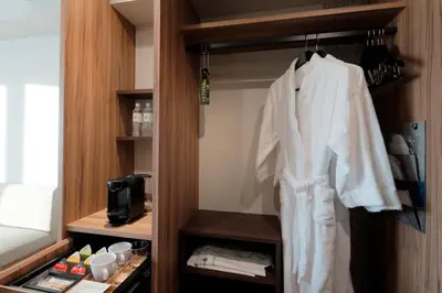 a room with a robe hanging from a closet at Miyako City Tokyo Takanawa in Tokyo