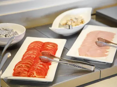 a table with plates of food with meat and utensils at Miyako City Tokyo Takanawa in Tokyo