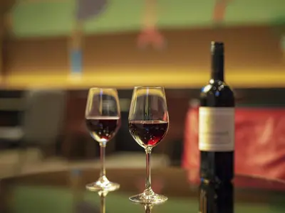 two glasses of red wine next to a bottle of wine at Miyako City Tokyo Takanawa in Tokyo