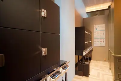 a locker room with black cabinets and a row of lockers at Miyako City Tokyo Takanawa in Tokyo