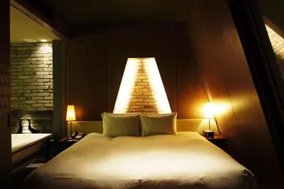 a bedroom with a bed with a light above it at Shibuya Granbell Hotel in Tokyo