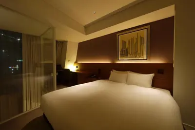 a large white bed in a room with a window at Shibuya Granbell Hotel in Tokyo