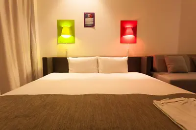 a bedroom with a bed and two lamps on the wall at Shibuya Granbell Hotel in Tokyo