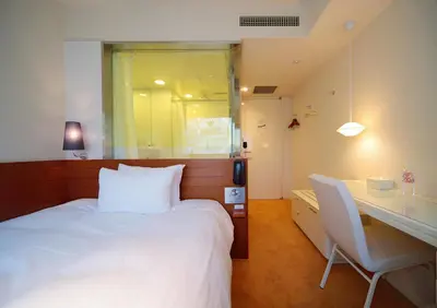 a bedroom with a white bed and a desk and a desk at Shibuya Granbell Hotel in Tokyo