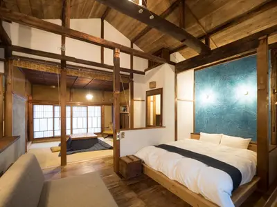 a bedroom with a large bed in a room with wooden ceilings at TOKYO LITTLE HOUSE in Tokyo