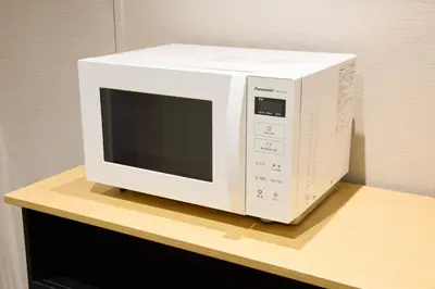 a white microwave sitting on top of a counter at Ginza International Hotel in Tokyo