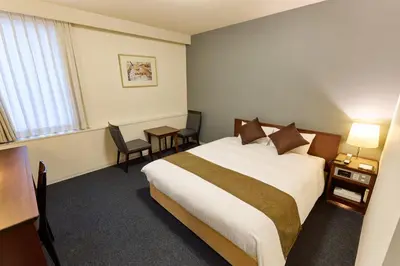 a hotel room with a bed and a table at Ginza International Hotel in Tokyo