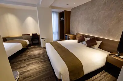 a hotel room with two beds and a table at Ginza International Hotel in Tokyo