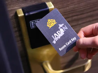 a person holding a purple tag on a camera at APA Hotel Kanda Ekihigashi in Tokyo