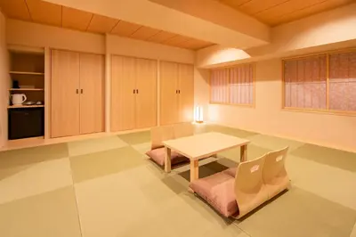 a living room with a table and a chair at karaksa hotel TOKYO STATION in Tokyo