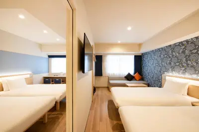 a hotel room with four beds and a couch at karaksa hotel TOKYO STATION in Tokyo