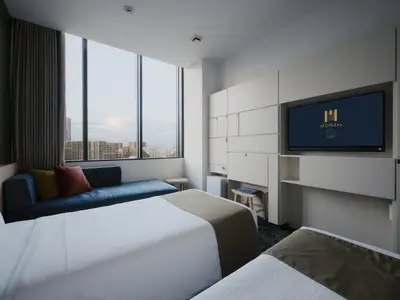 a hotel room with two beds and a flat screen tv at hotel MONday Premium TOYOSU in Tokyo