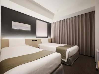 a hotel room with two beds and a window at hotel MONday Premium TOYOSU in Tokyo