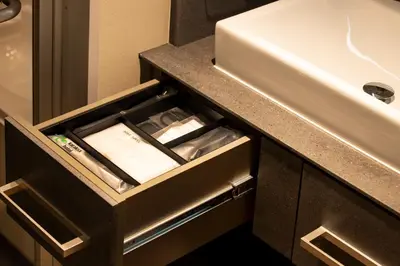 an open drawer in a bathroom with a sink at karaksa hotel premier Tokyo Ginza in Tokyo