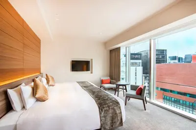 a bedroom with a large bed and a large window at karaksa hotel premier Tokyo Ginza in Tokyo