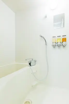 a shower in a white bathroom with a sink at KAGO 34 Tokyo by Shukuba HOTEL in Tokyo