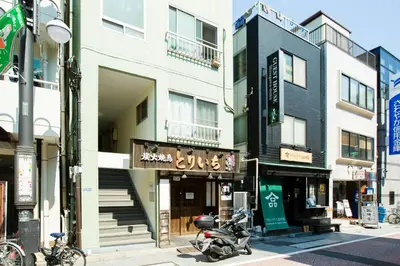 a motorcycle parked in front of a building on a street at KAGO 34 Tokyo by Shukuba HOTEL in Tokyo