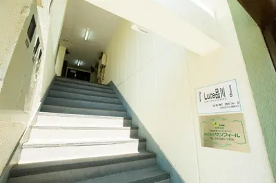 a staircase in a building with a sign on the wall at KAGO 34 Tokyo by Shukuba HOTEL in Tokyo