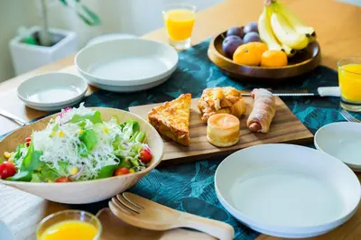 a table with plates and bowls of food and a salad at KAGO 34 Tokyo by Shukuba HOTEL in Tokyo