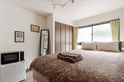 a bedroom with a large bed and a television at Papa101 in Tokyo