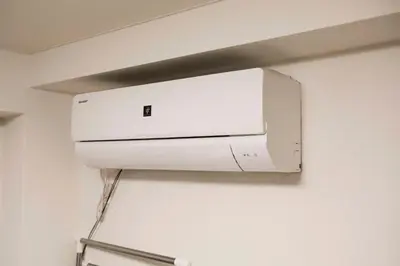 a white air conditioner hanging on a wall at Papa101 in Tokyo