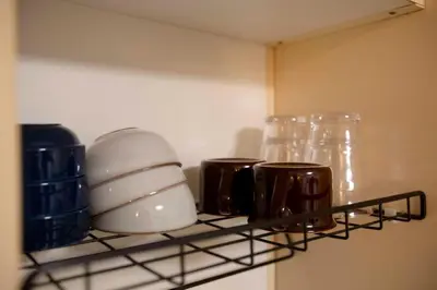 a shelf in a kitchen with dishes and glasses at Papa101 in Tokyo