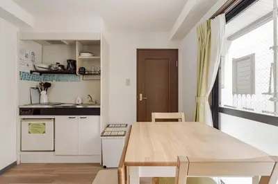 a kitchen with a wooden table and a dining room at Papa101 in Tokyo