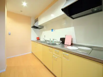 a kitchen with yellow cabinets and a sink at COZY INN Tokyo Sakura Town in Tokyo