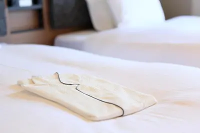 a white towel sitting on top of a bed at HOTEL SUI KANDA by ABEST in Tokyo