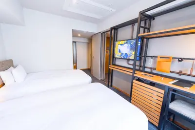 a hotel room with two beds and a tv at ICI HOTEL Asakusabashi in Tokyo