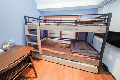 a bedroom with two bunk beds and a desk at Stylewood Sangenjaya by Tranova in Tokyo