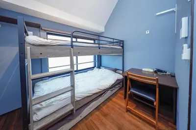 a room with two bunk beds and a desk and a deskablishthritisthritisthritis at Stylewood Sangenjaya by Tranova in Tokyo