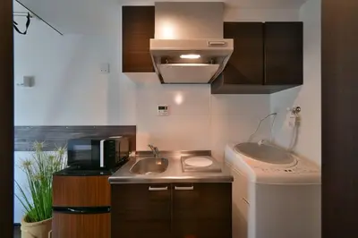 a small kitchen with a sink and a microwave at Stylewood Sangenjaya by Tranova in Tokyo