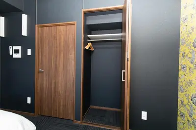 a room with a closet with a wooden door at Guest House One More Heart at TSUKIJI 1 in Tokyo
