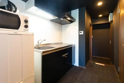 a small kitchen with a sink and a microwave at Guest House One More Heart at TSUKIJI 1 in Tokyo