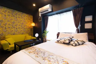 a bedroom with a bed and a yellow chair at Guest House One More Heart at TSUKIJI 1 in Tokyo