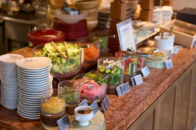 a buffet with plates and bowls of food on a counter at Hotel Resol Akihabara in Tokyo