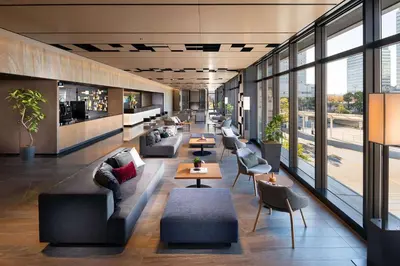 a lobby with couches and tables and windows at DoubleTree by Hilton Tokyo Ariake in Tokyo