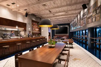 a restaurant with wooden tables and chairs and a bar at DoubleTree by Hilton Tokyo Ariake in Tokyo