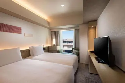 a hotel room with two beds and a flat screen tv at DoubleTree by Hilton Tokyo Ariake in Tokyo