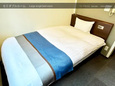 a bedroom with a bed with a blue and white blanket at Cypressinn Tokyo in Tokyo