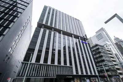 a tall building in a city with tall buildings at remm Tokyo Kyobashi in Tokyo