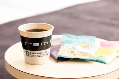 a cup of coffee and a book on a table at remm Tokyo Kyobashi in Tokyo