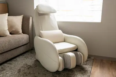 a white chair in a living room next to a couch at remm Tokyo Kyobashi in Tokyo