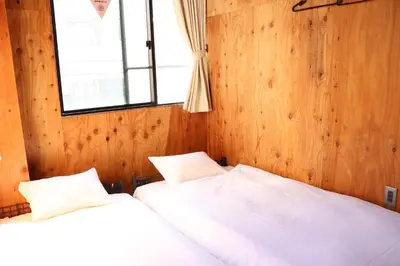 two white beds in a room with a window at Focus Kuramae in Tokyo